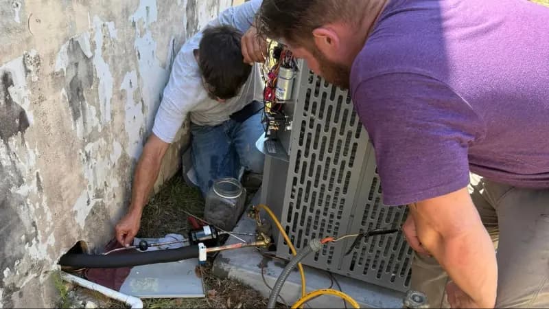 Professional HVAC technicians from Perfected Air Solutions installing new central air conditioning system in Panama City FL home with proper ductwork and electrical connections