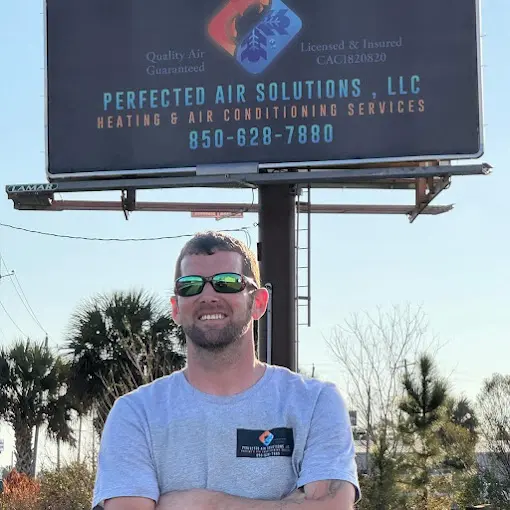 Perfected Air Solutions owner standing in front of company billboard